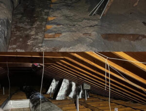 attic space with exposed wooden rafters, hanging wires, and a large round hvac duct running along the joists.